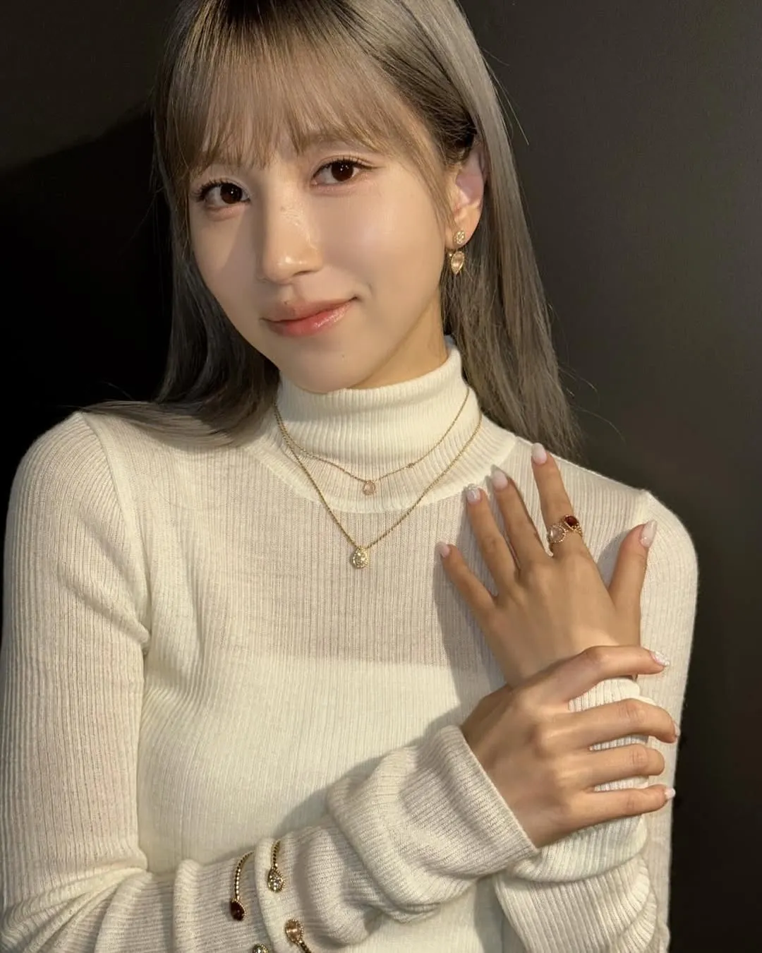 Áo cổ lọ dệt kim trắng giúp tổng thể trang phục không bị nặng nề.