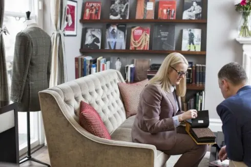 Kathryn trao đổi về chất liệu vải bên cạnh một khách hàng.