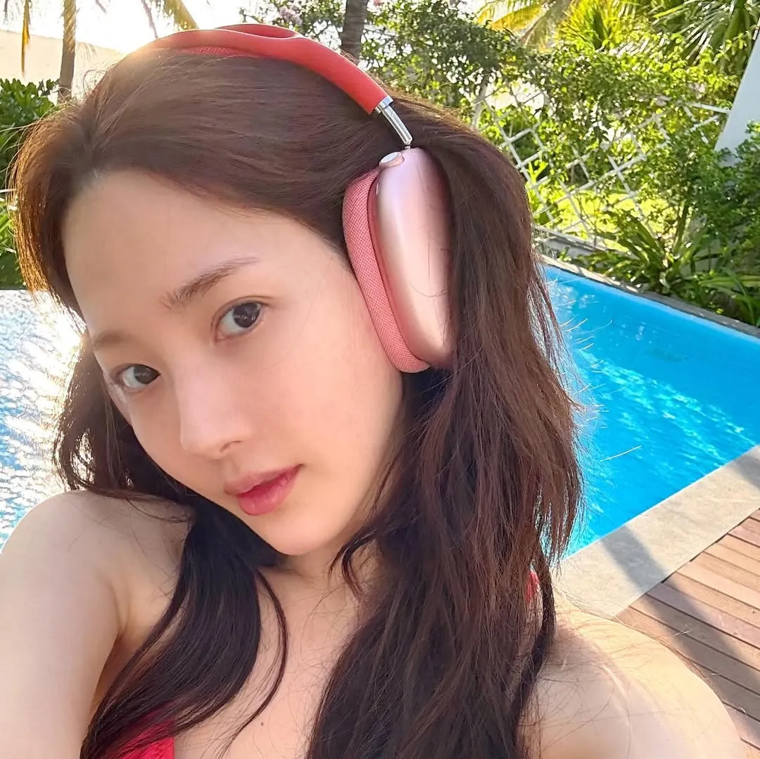 Hình ảnh Park Min Young selfie bên hồ bơi và bãi biển để minh họa cho các món đồ đi biển mùa Hè.