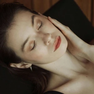 Người phụ nữ chạm nhẹ vào mặt, khoe làn da mịn màng