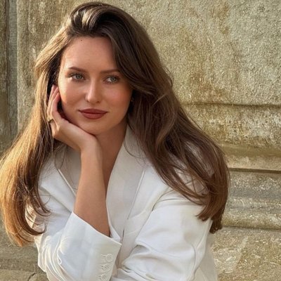 mùi hương - cô gái Pháp mặc blazer và tạo dáng ngồi chống cằm selfie