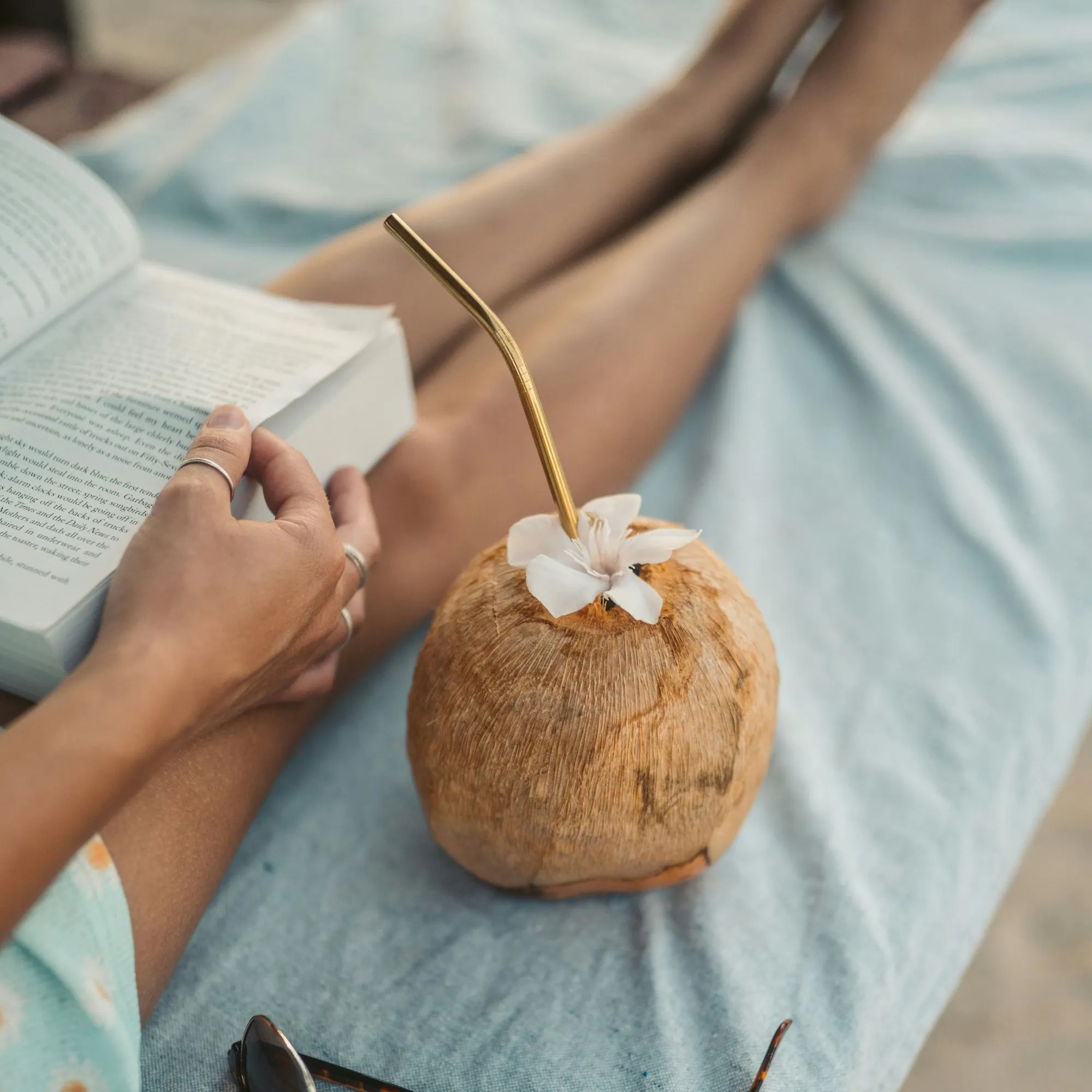 Cô gái đọc sách và uống nước dừa ngày nắng nóng