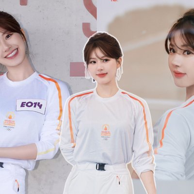 Triệu Lộ Tư mặc đồ thể thao màu trắng và mỉm cười tạo dáng để chụp hình tại Lễ rước đuốc Olympic Paris 2024