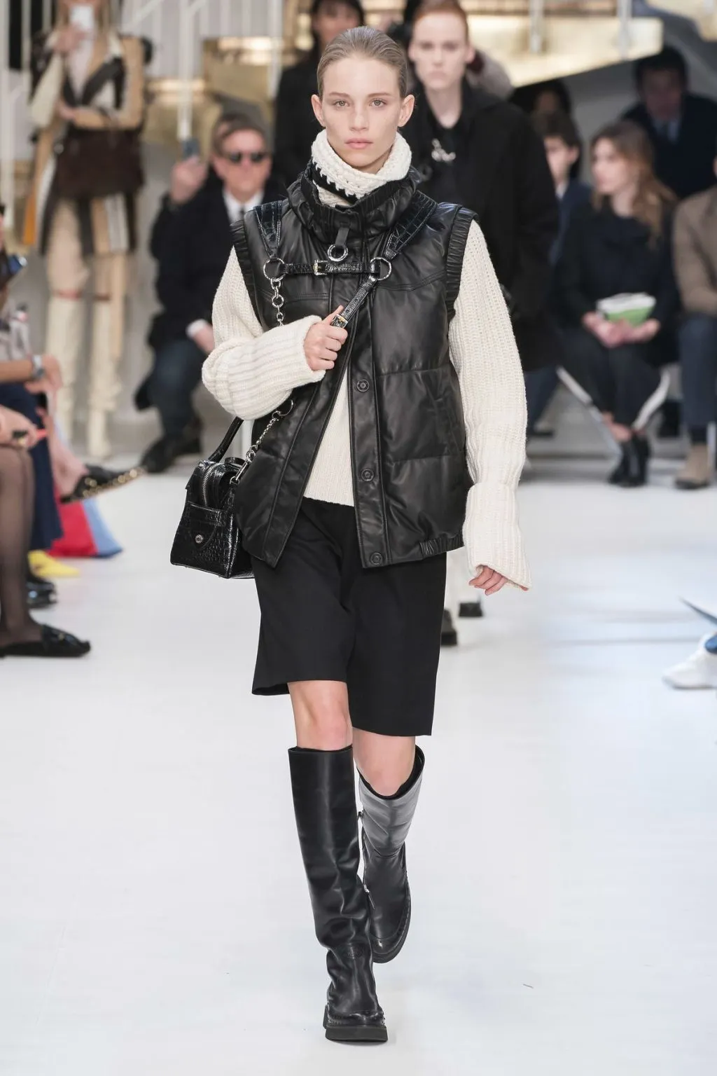 Layer áo gile phao đen cùng áo len cổ cao màu trắng - màu sắc đối ngược càng tăng thêm vẻ độc đáo cho outfit. 