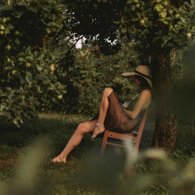 cô gái ngồi tựa trên ghế dưới gốc cây ăn quả tử vi ngày 24/3/2026