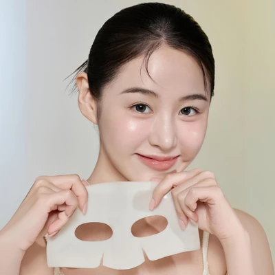 Cô gái tạo dáng với mặt nạ dưỡng ẩm trước ống kính.