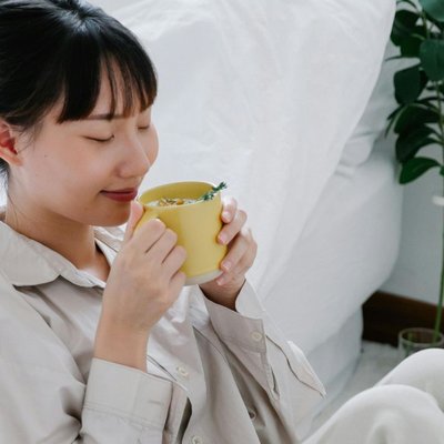 Phụ nữ nhắm mắt uống trà thảo mộc