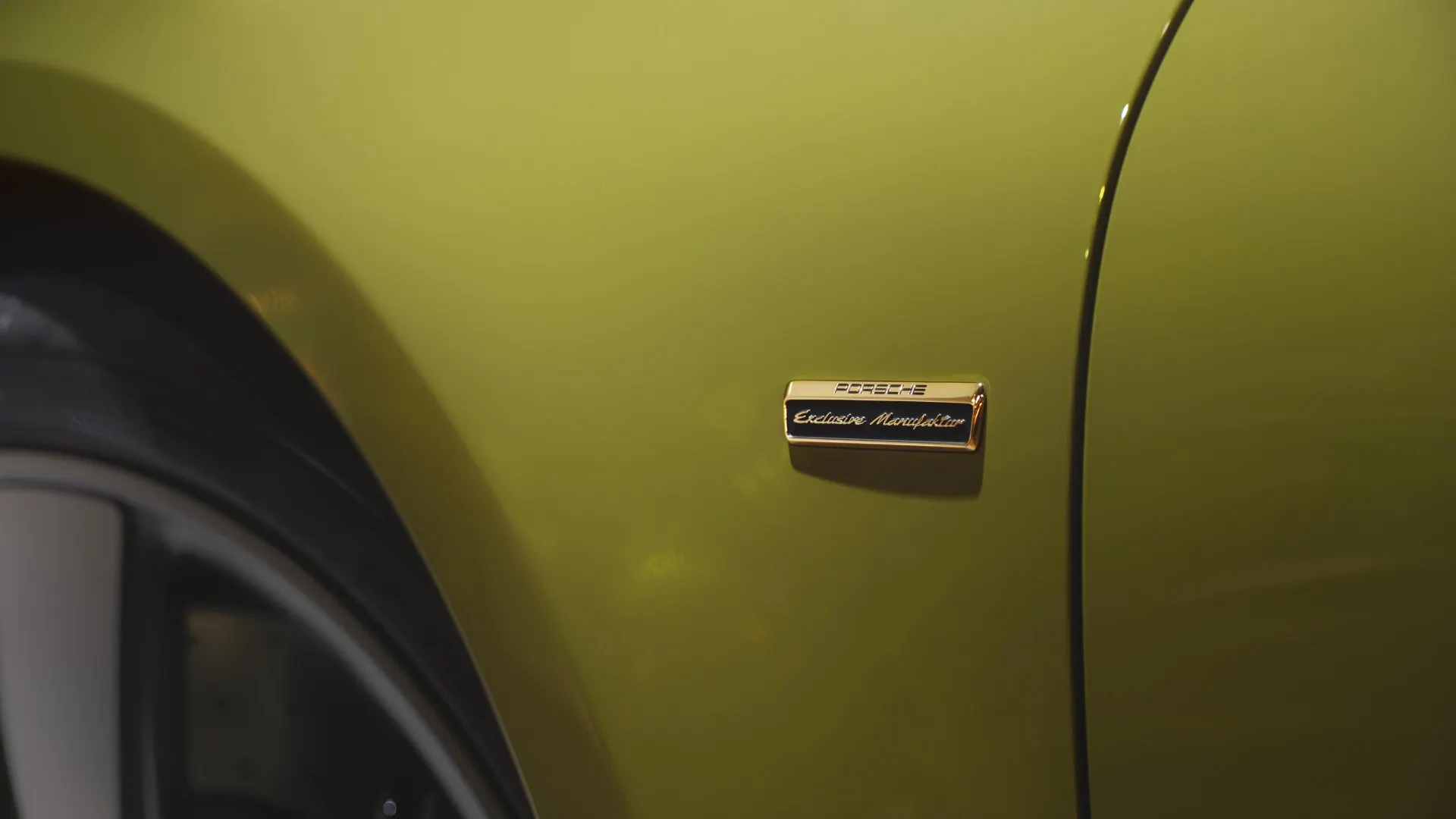Hai tấm ốp chắn bánh xe trước được đính huy hiệu “Porsche Exclusive Manufaktur” màu vàng ánh kim.