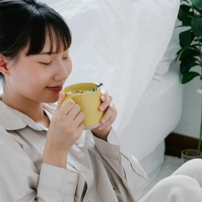 Phụ nữ nhắm mắt uống trà thảo mộc
