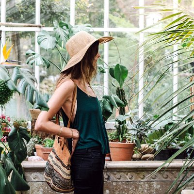 cô gái mặc áo dây màu xanh đứng giữa nhà kính