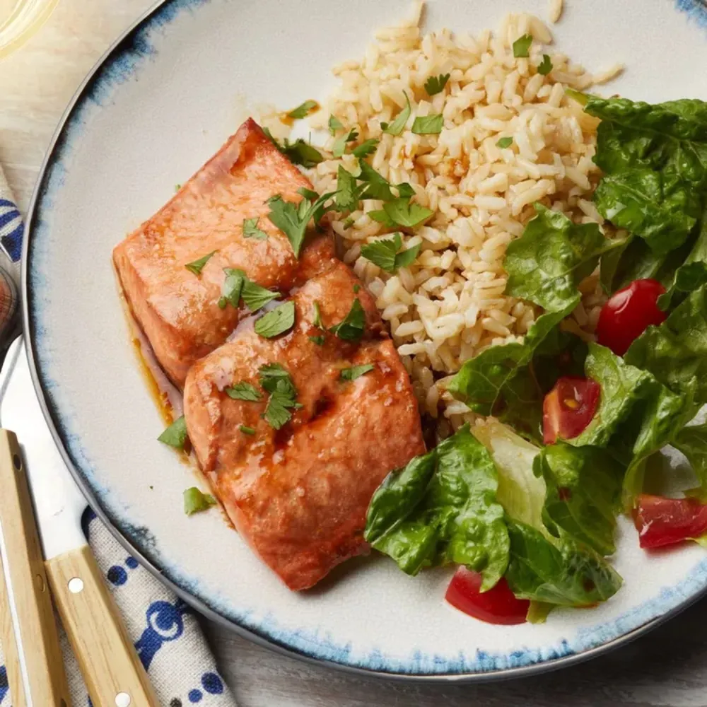 Cá hồi áp chảo dùng kèm với cơm và salad.