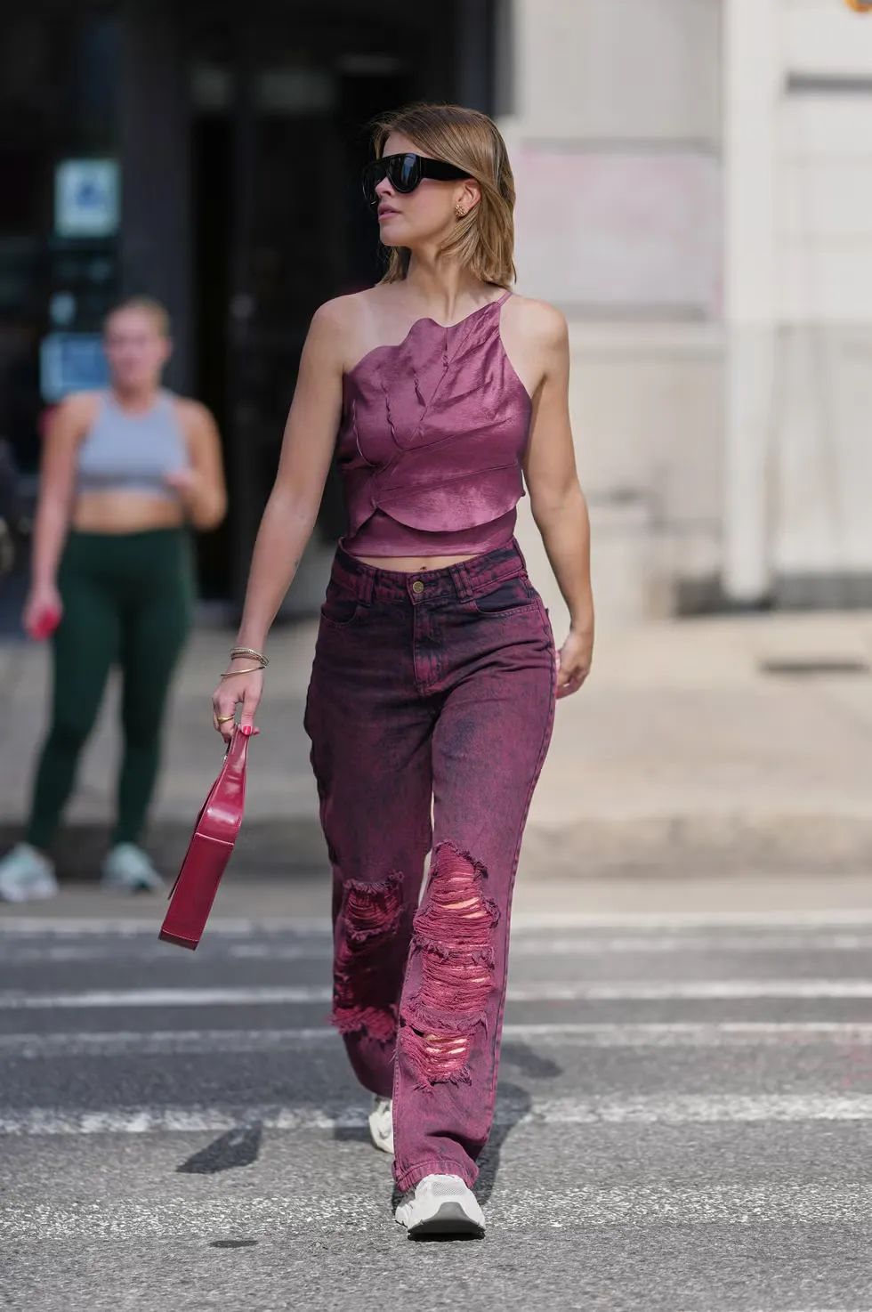 Nâng tầm chiếc quần jeans rách bằng một chiếc áo satin lệch vai bắt mắt và sang trọng.