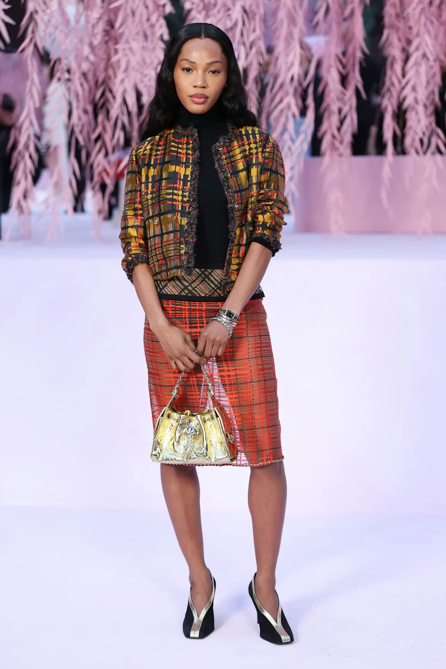 Quenlin Blackwell: Ngôi sao trẻ khuấy động không khí bằng bản phối đầy táo bạo giữa áo khoác tweed caro vàng nâu truyền thống và chân váy lưới xuyên thấu hiện đại.