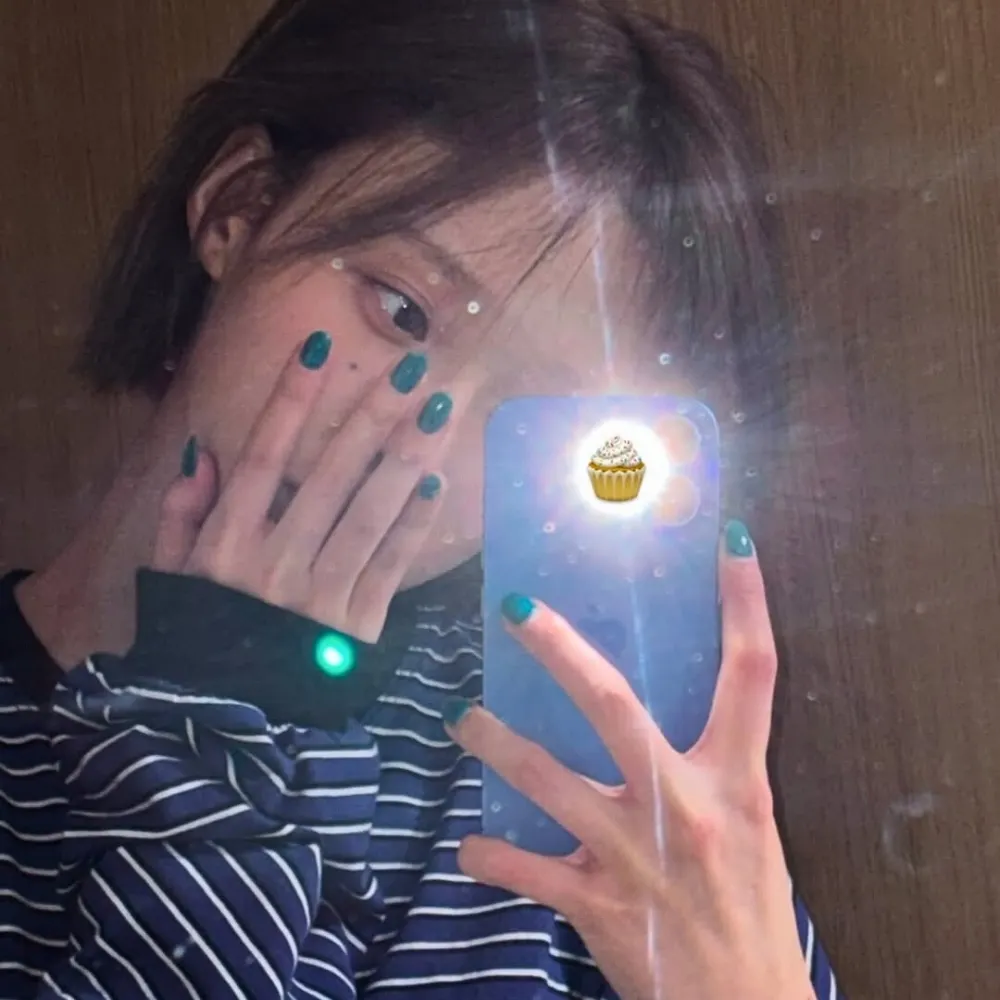 Winter (aespa) để tay với mẫu nail màu xanh lên mặt