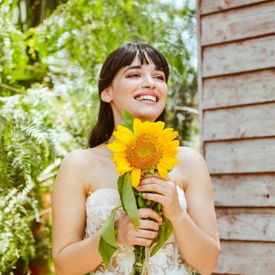 cô gái cầm hoa hướng dương có dấu hiệu tích cực và rạng rỡ