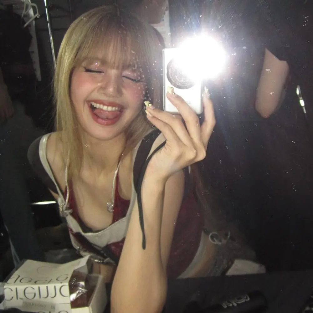 Lisa (BLACKPINK) chụp ảnh trước gương với mẫu nail vàng tại concert