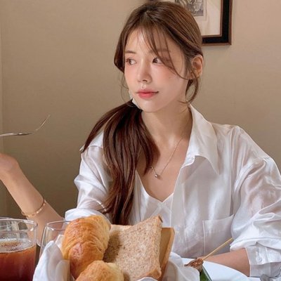 Cô gái ngồi ăn sáng với bánh mì