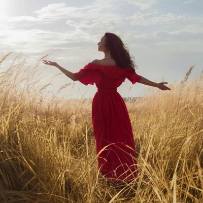 cô gái mặc váy đỏ dang tay trên cánh đồng tử vi ngày 25/12/2025