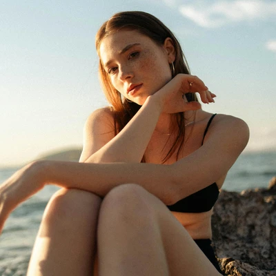 cô gái đang ngồi bên bãi biển