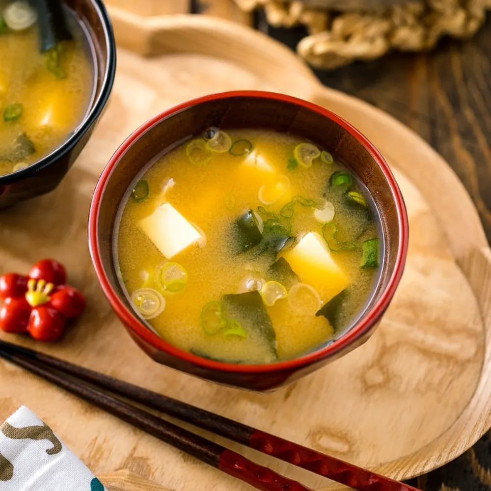 Chén canh miso chứa đậu hũ và hành lá.