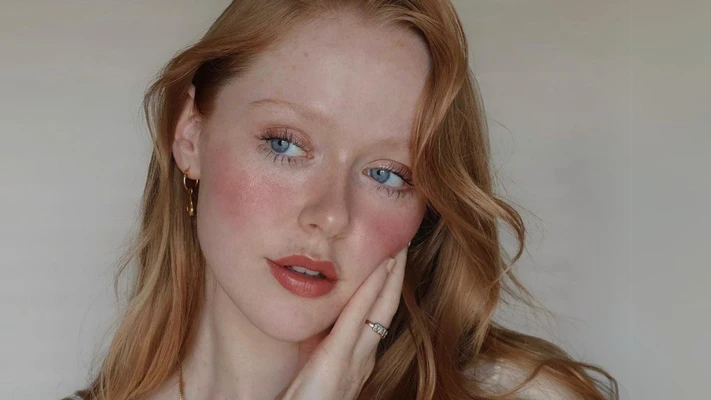 demure - cô gái châu Âu nhuộm tóc màu nâu vàng và trang điểm tone đỏ hồng để selfie