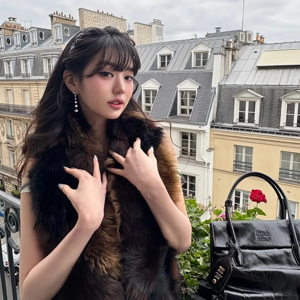 Jang Wonyoung choàng áo khoác lông và đặt hai tay lên áo