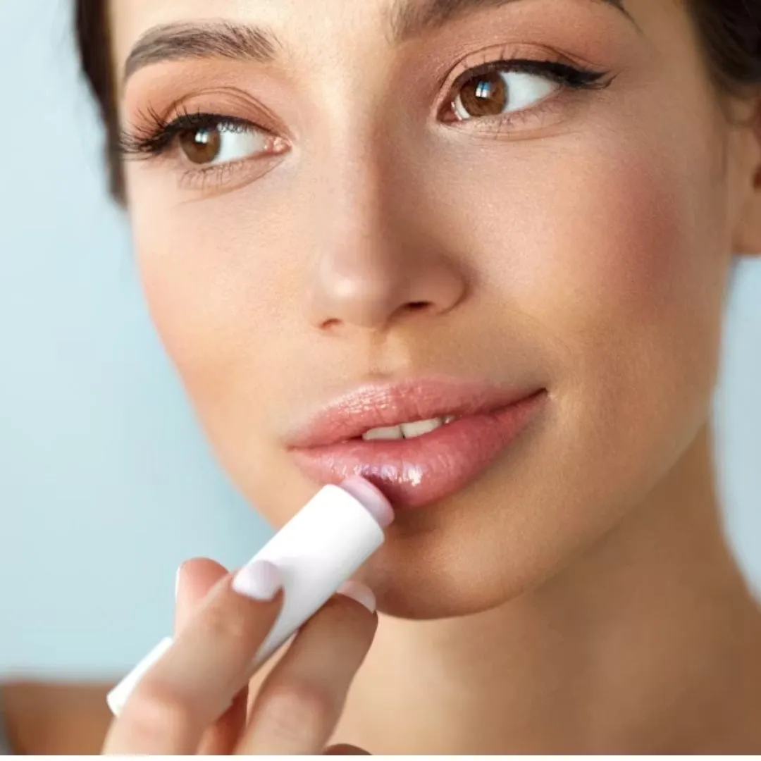 cô gái đang thoa son dưỡng môi có thể gây mụn cằm