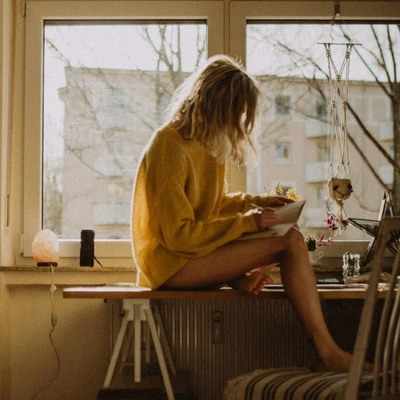cô gái ngồi viết bên cửa sổ