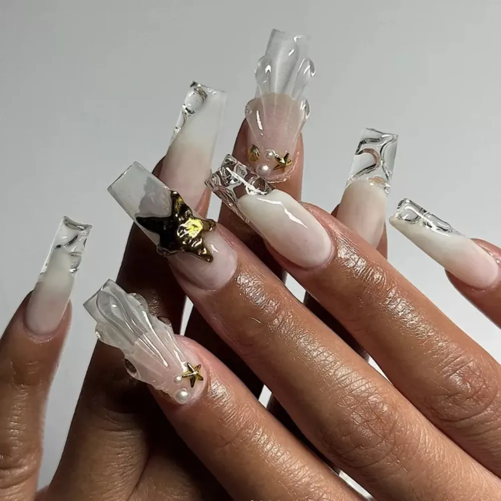 Móng tay trắng sữa gắn họa tiết sao biển và vỏ sò.