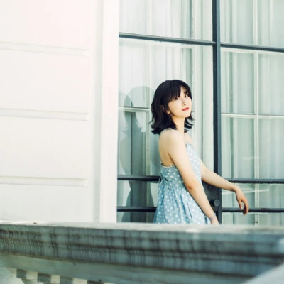 cô gái đứng trên ban công có thói quen tắm nắng buổi sáng