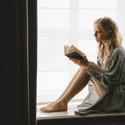 cô gái ngồi đọc sách bên cửa sổ có khả năng đồng cảm