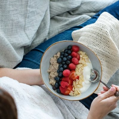 Cô gái ăn sữa chua trái cây khắc phục chứng đầy hơi.