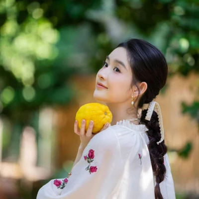 Vương Ngọc Văn dịu dàng với tóc tết thấp buộc bằng dây vải mềm, kết hợp áo blouse trắng họa tiết hoa mang vẻ đẹp thanh thoát và cổ điển.