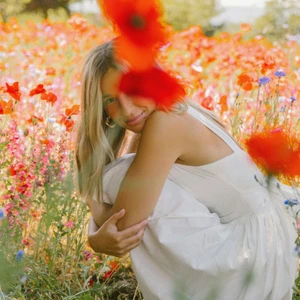 Cô gái tóc vàng đầm trắng ngồi giữa cánh đồng hoa anh túc có thói quen trẻ lâu