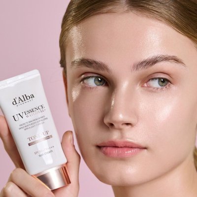 Cô gái cầm kem chống nắng d’Alba.