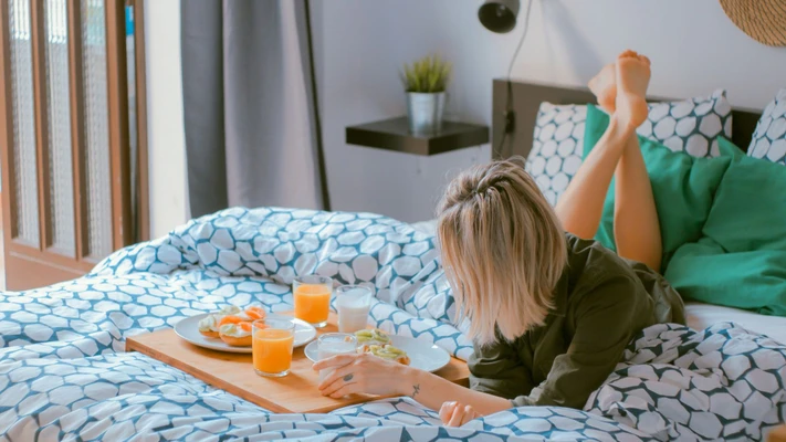 Cô gái nằm trên giường ăn sáng - chế độ ăn