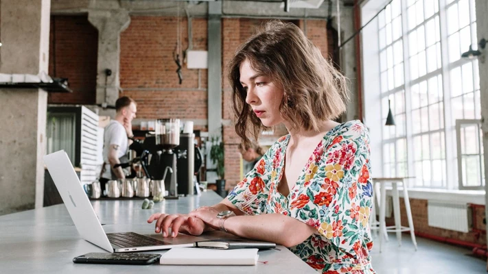 cô gái sử dụng laptop trong quán cà phê