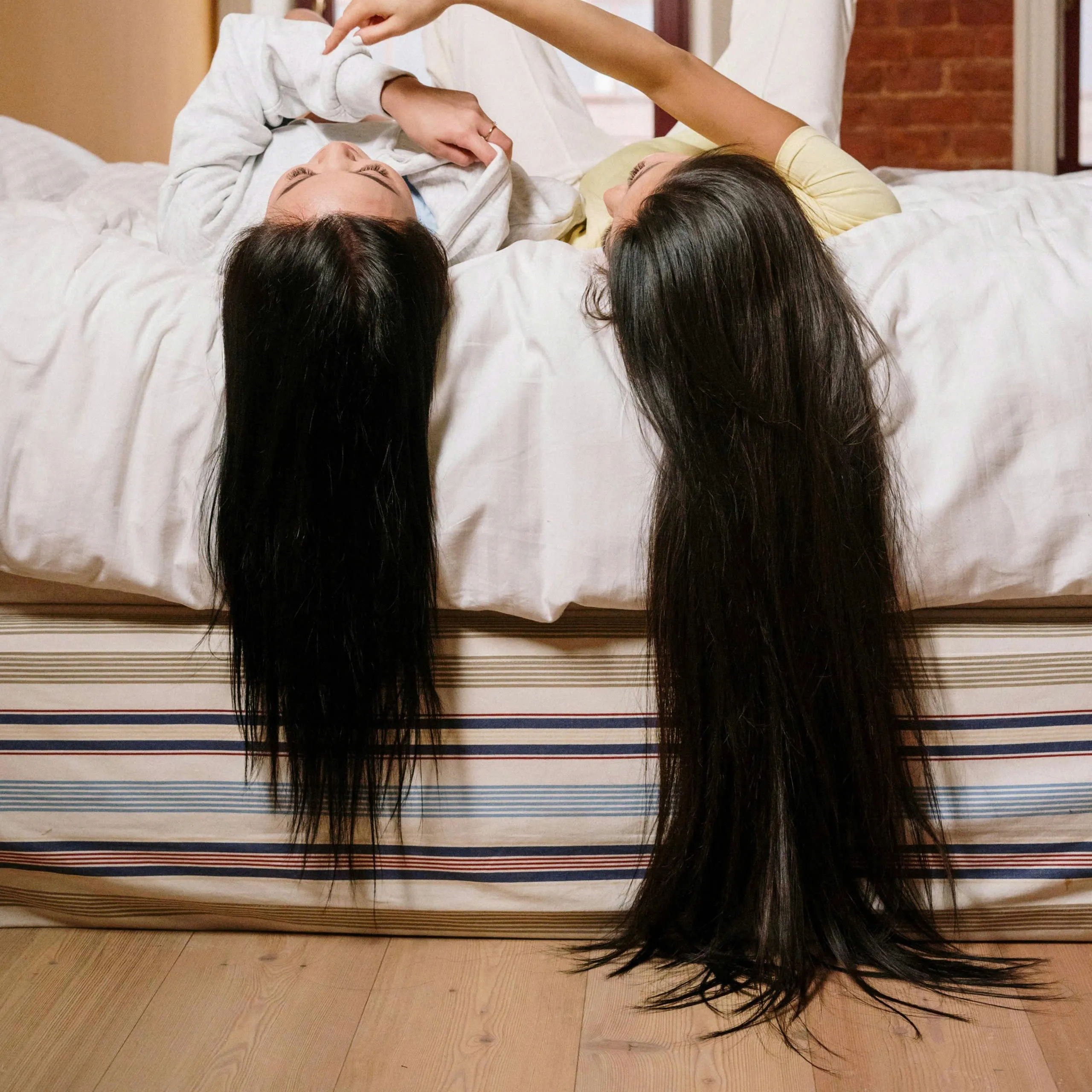 2 cô gái đang nằm xõa tóc - dưỡng tóc bằng dầu dừa