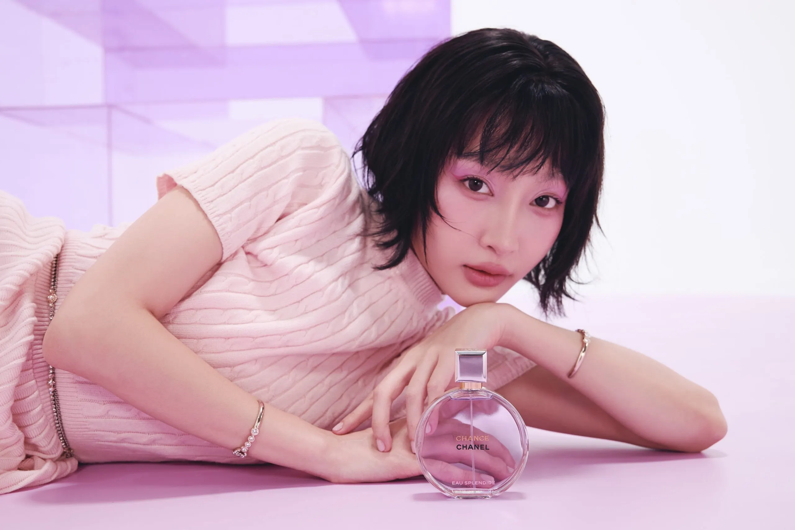 Juky San nằm nghiêng cầm lọ nước hoa Chanel Chance Eau Splendide