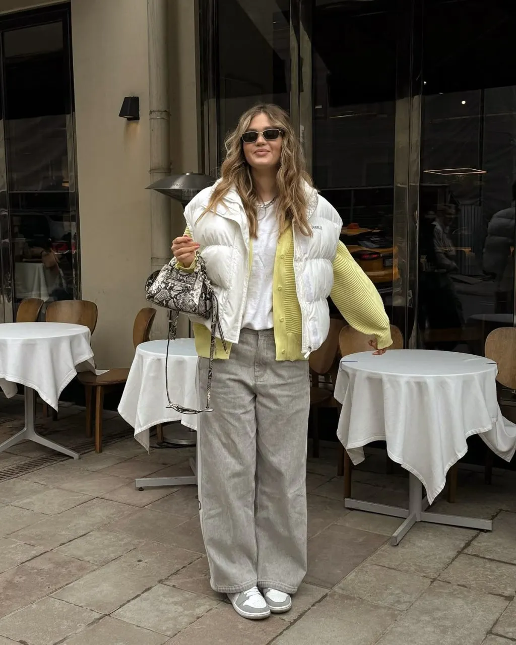 Layering áo phao gile cùng áo cardigan màu vầng pastel vừa nữ tính vừa ấm áp. 