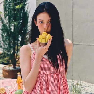 Cô gái mang áo caro đỏ ăn loại quả giàu chất béo tốt.