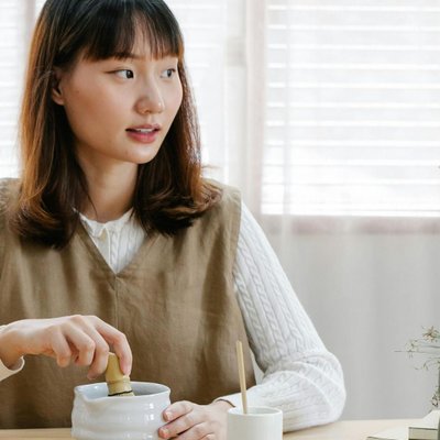 Cô gái đang ngồi pha trà xanh.
