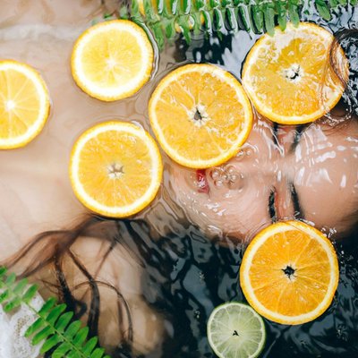 người phụ nữ ngâm mình trong bồn nước có cam