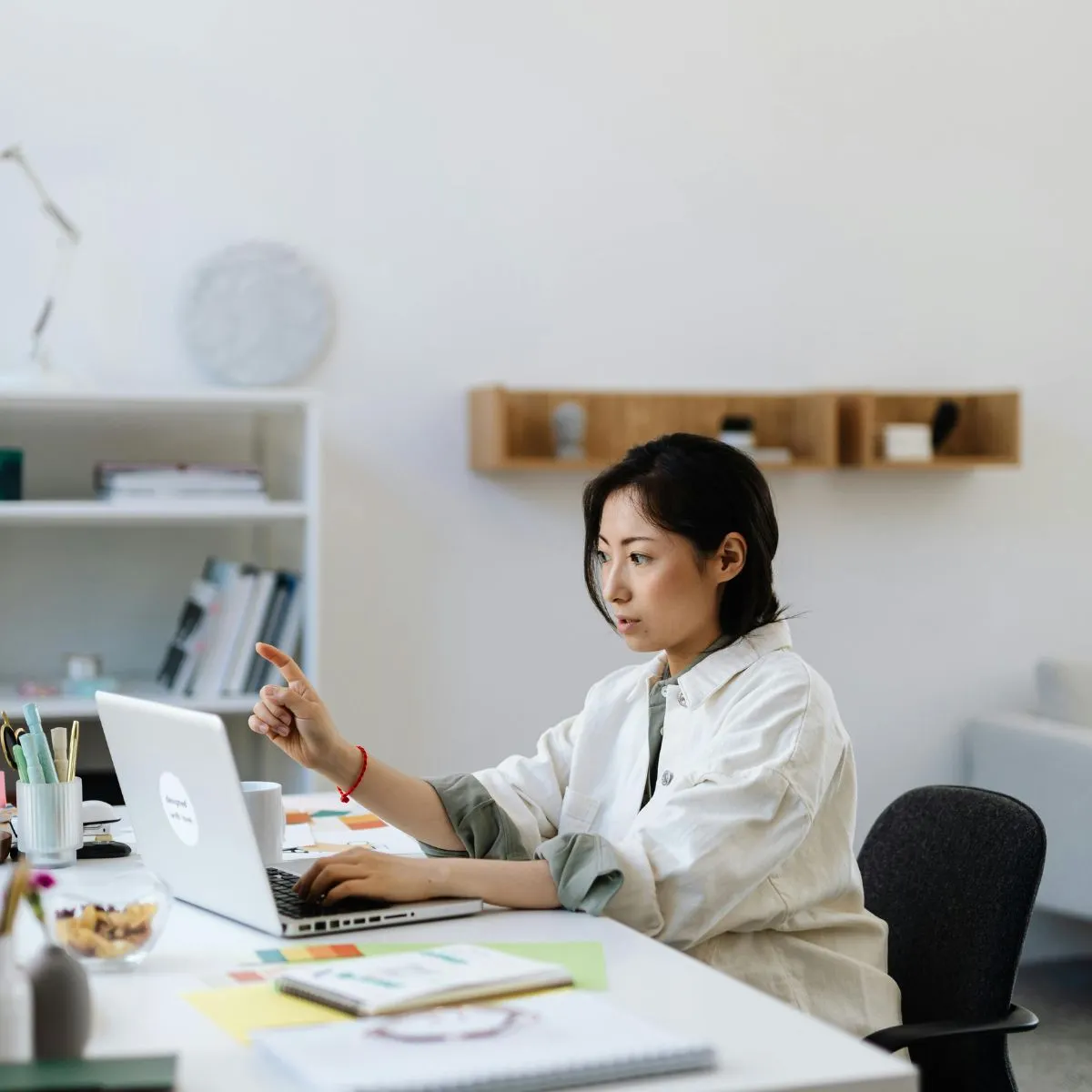 Cô gái áo sơ mi trắng ngồi ở bằng làm việc đang hướng dẫn thực hiện bài trấc nghiệm xác định phong cách lãnh đạo