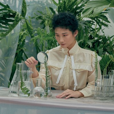 cô gái cầm kính lúp soi cây bền vững