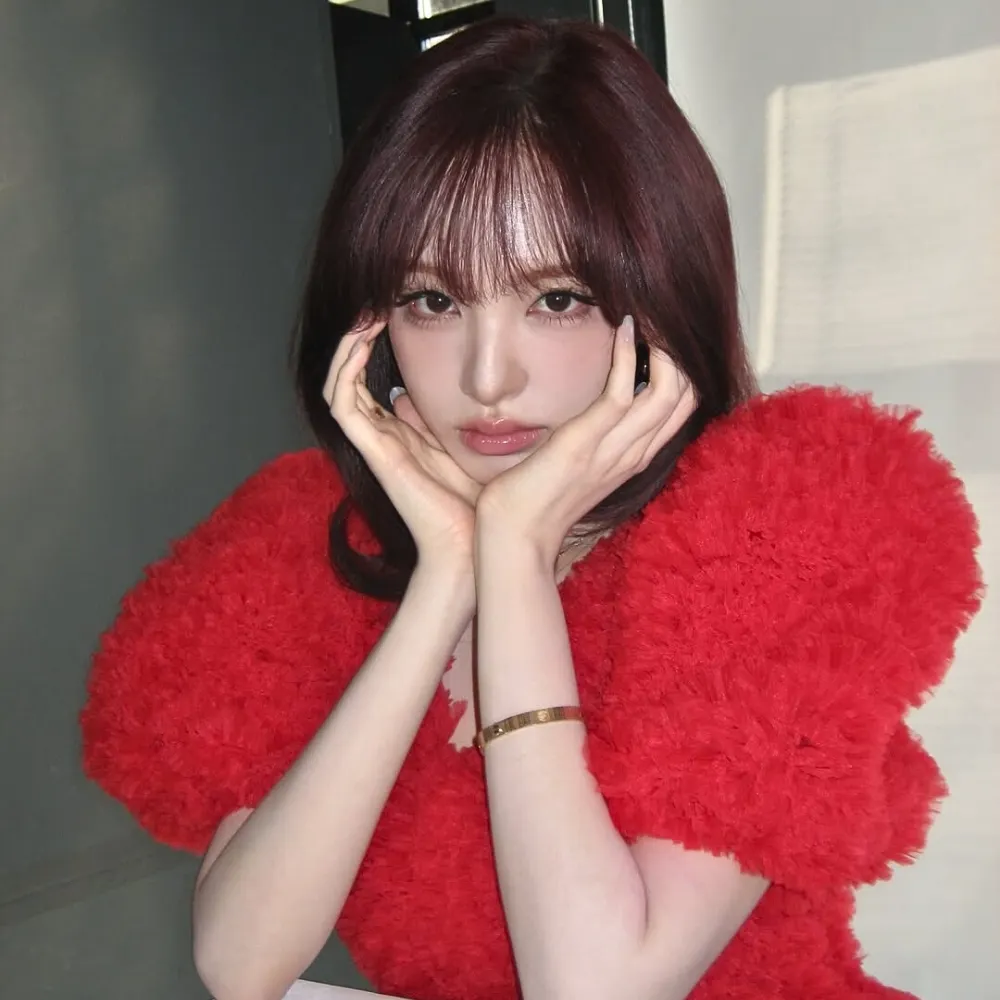 cô gái mang áo đỏ chống tay lên cằm