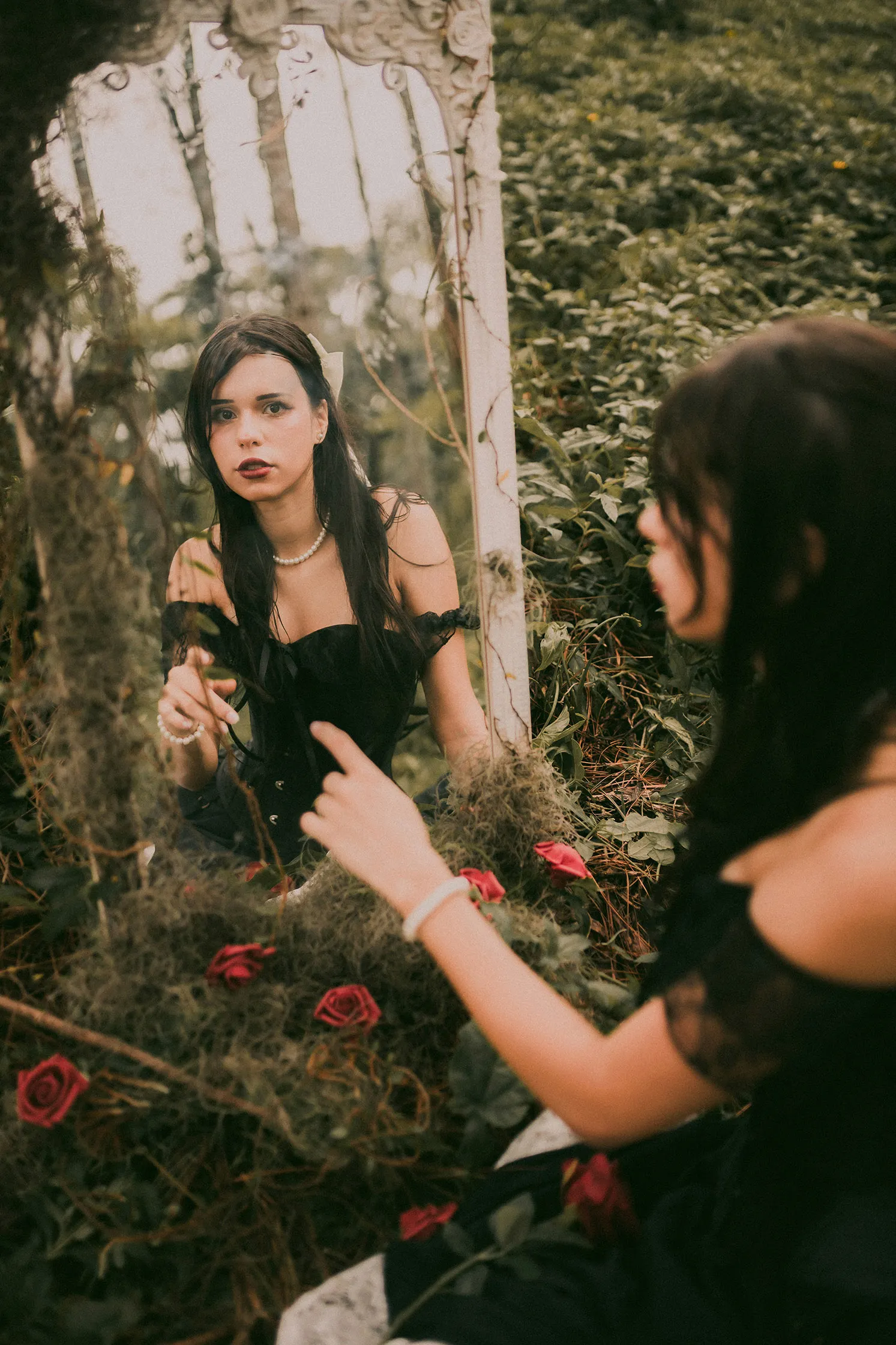 cô gái mặc đầm đen chỉ tay nhìn mình trong gương