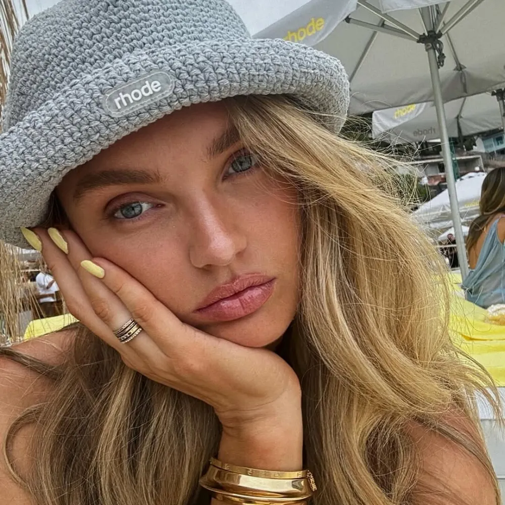 Romee Strijd đội mũ len, diện mẫu nail màu vàng và chống tay lên mặt