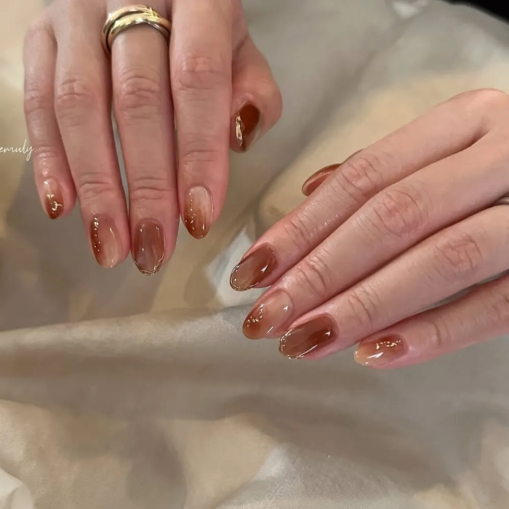 đôi tay với bộ nail nâu ombre