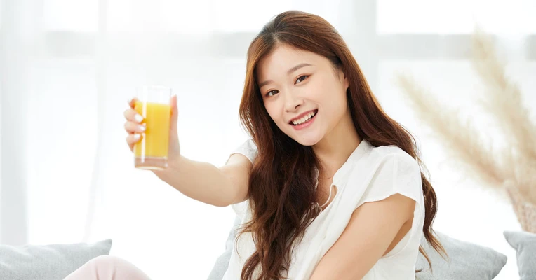 Cô gái cầm ly nước cam.